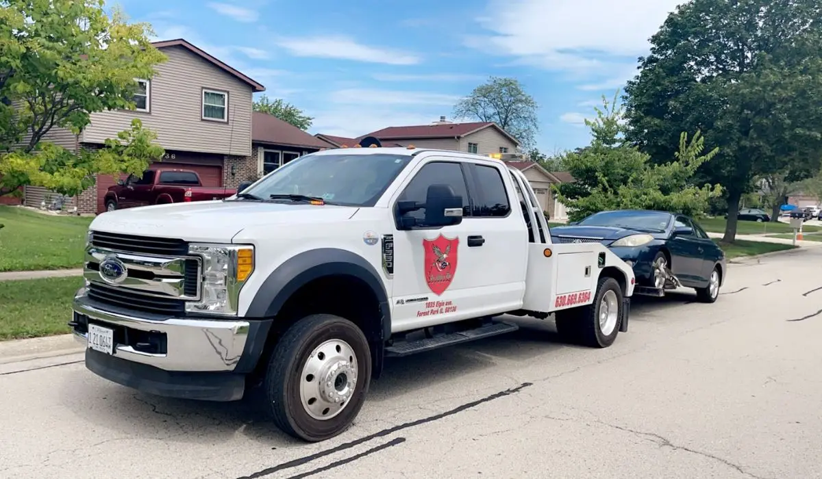 Tow truck picking up a junk car in Willowbrook showing junk car removal for single moms with fast and reliable service.