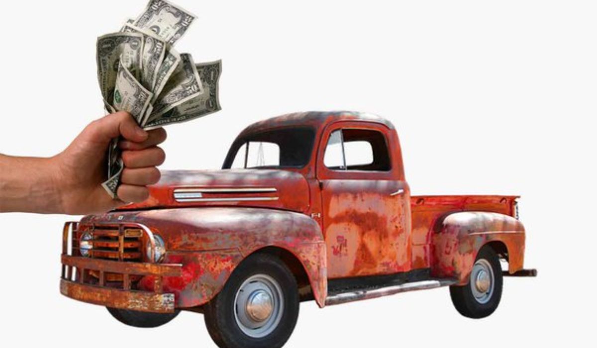image of a rusty old truck and a hand full of bills