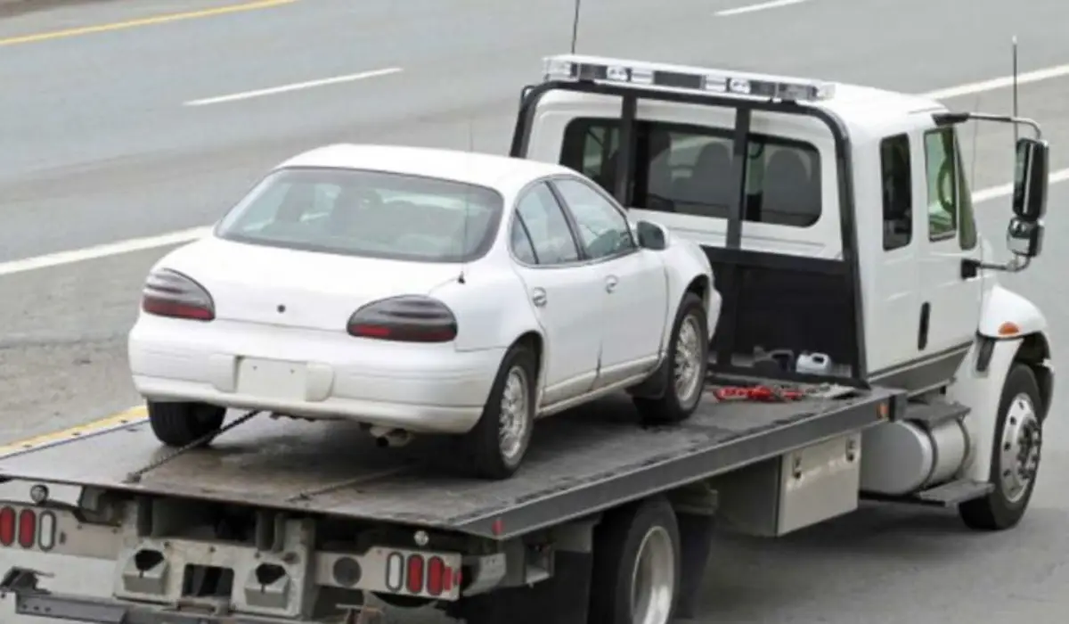a white small car carried away by a tow truck