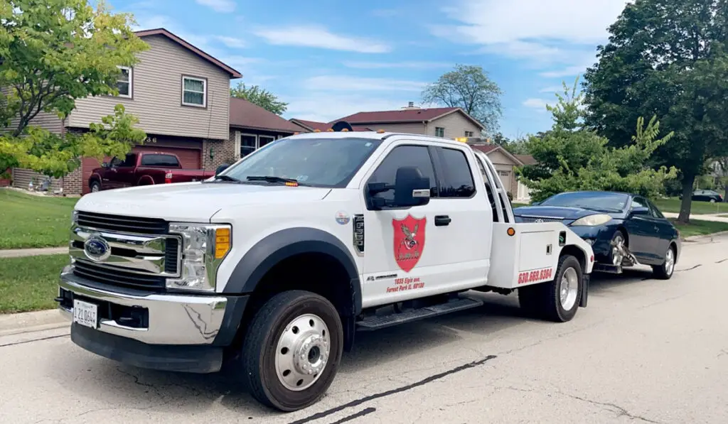 White towing truck with a junk car, Cash for Junk Cars