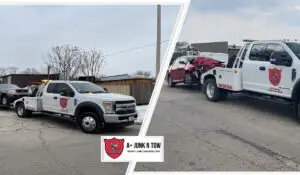 two white tow trucks towing a junk car