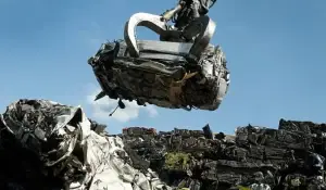 A hydraulic claw lifting a car for recycling at a scrap yard, part of the "scrap my car" process.