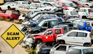 Scam when selling your junk car warning sign in front of junk vehicles.